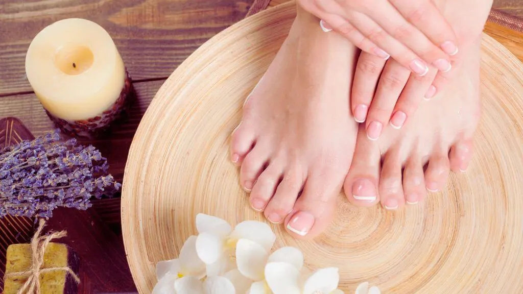 Spa-Ready Feet – Perfect for High-Quality Feet Pictures Well-groomed female feet and hands resting in a wooden bowl surrounded by spa elements, ideal for promoting professional feet pictures.